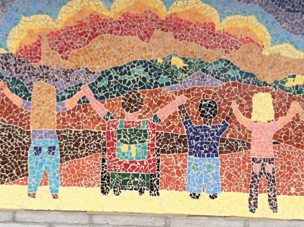 Mosaic holding hands Image of tile mosaic showing children looking at the mountain